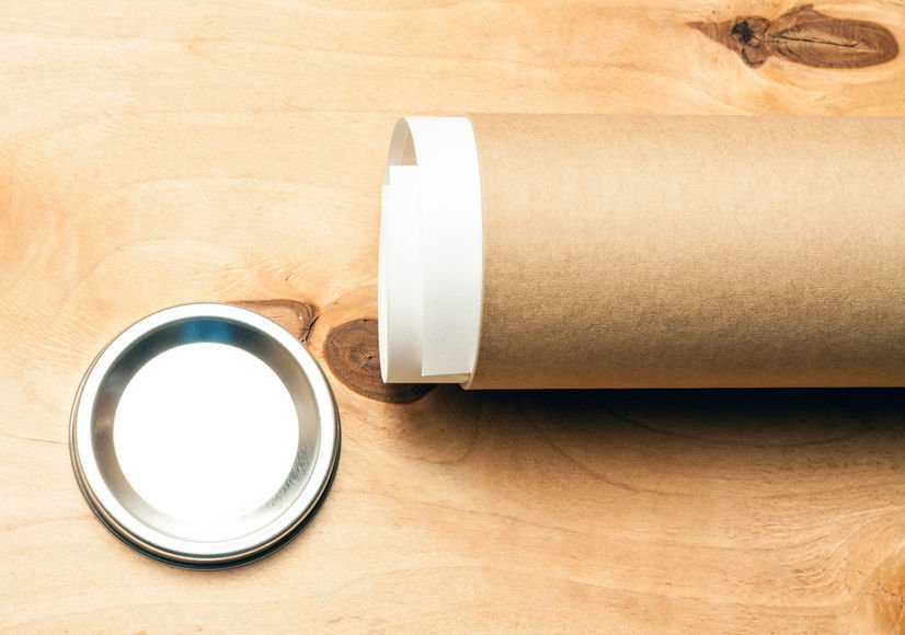 Kraft mailing tube with metal end cap on a wooden table
